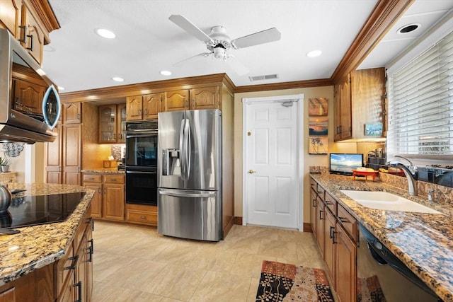 10432 Sandpiper Rd W, Bradenton, FL 34209 - kitchen with black appliances, a sink, brown cabinetry, and visible vents