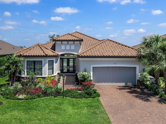 15037 Montello Way, Lakewood Ranch, FL 34211 - mediterranean / spanish-style home featuring a tile roof, decorative driveway, an attached garage, stucco siding, and french doors
