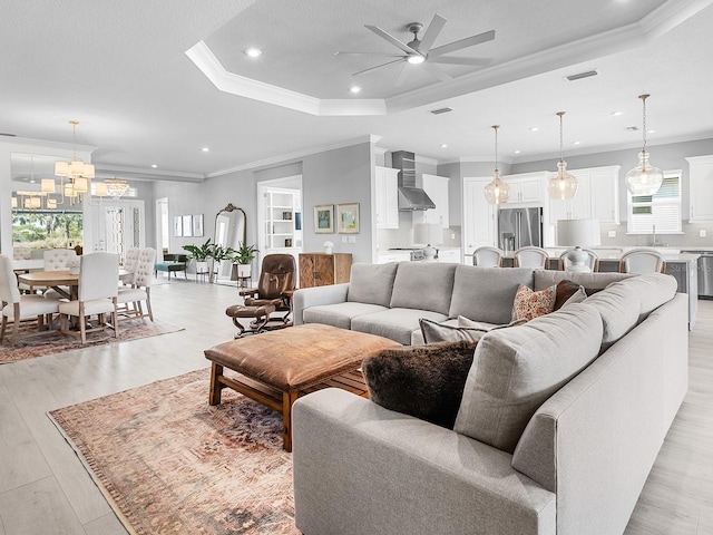 15037 Montello Way, Lakewood Ranch, FL 34211 - living area with recessed lighting, light wood-style flooring, ornamental molding, ceiling fan with notable chandelier, and a raised ceiling