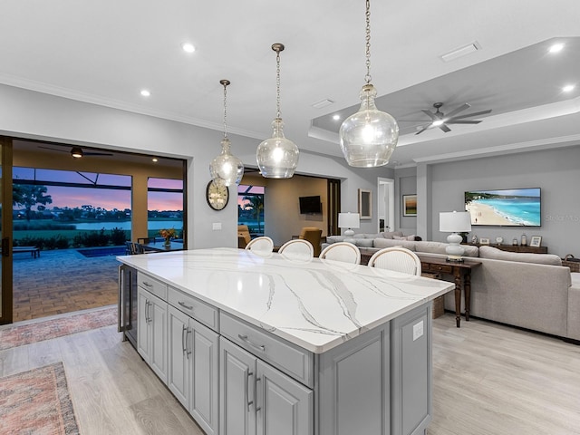 15037 Montello Way, Lakewood Ranch, FL 34211 - kitchen with light wood finished floors, recessed lighting, gray cabinets, a center island, and a ceiling fan