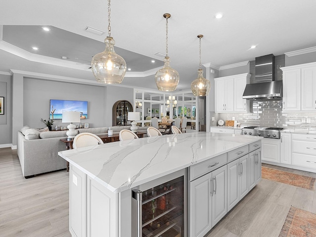 15037 Montello Way, Lakewood Ranch, FL 34211 - kitchen with beverage cooler, light wood-style floors, open floor plan, ornamental molding, and wall chimney exhaust hood