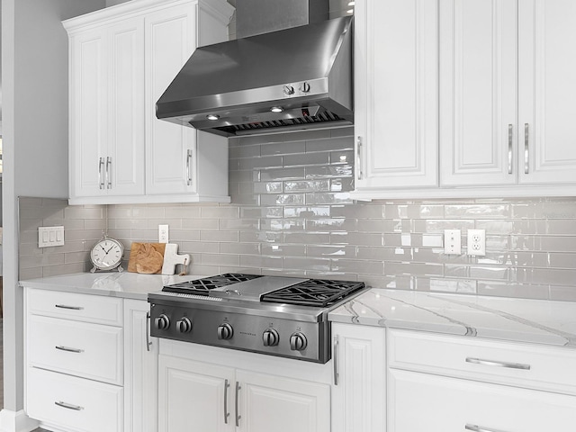 15037 Montello Way, Lakewood Ranch, FL 34211 - kitchen featuring stainless steel gas cooktop, decorative backsplash, light stone counters, wall chimney range hood, and white cabinets