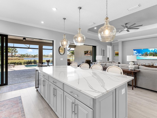 15037 Montello Way, Lakewood Ranch, FL 34211 - kitchen with light wood-style floors, visible vents, open floor plan, and a center island