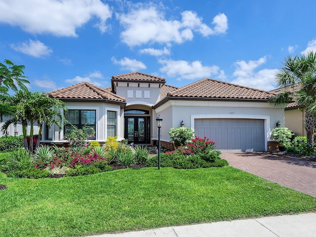 15037 Montello Way, Lakewood Ranch, FL 34211 - mediterranean / spanish-style house featuring a front lawn, stucco siding, driveway, an attached garage, and french doors