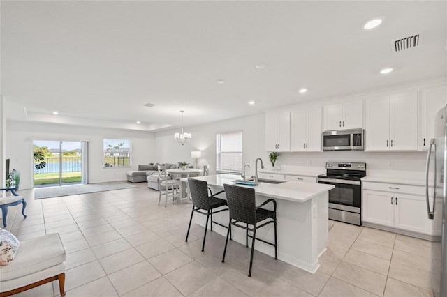 9725 Last Light Gln, Parrish, FL 34219 - kitchen with appliances with stainless steel finishes, open floor plan, light countertops, light tile patterned floors, and a breakfast bar area