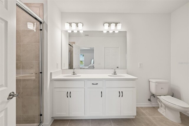 9725 Last Light Gln, Parrish, FL 34219 - full bath with double vanity, toilet, a stall shower, tile patterned floors, and baseboards