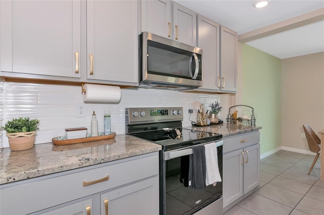 2969 Great Abaco Way, Bradenton, FL 34208 - kitchen with stainless steel appliances, backsplash, light tile patterned floors, and baseboards