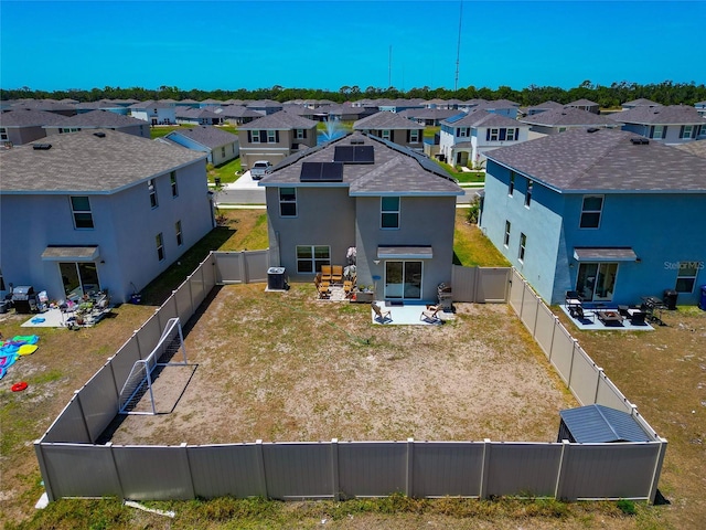 2969 Great Abaco Way, Bradenton, FL 34208 - back of property with a residential view, stucco siding, a patio, roof mounted solar panels, and a fenced backyard