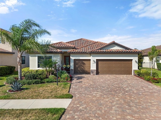 14309 Carolina Sky Pl, Lakewood Ranch, FL 34211 - mediterranean / spanish home with an attached garage, a tile roof, decorative driveway, and stucco siding