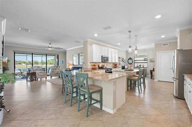 14309 Carolina Sky Pl, Lakewood Ranch, FL 34211 - kitchen featuring visible vents, ornamental molding, a peninsula, and appliances with stainless steel finishes