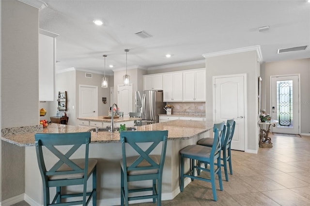 14309 Carolina Sky Pl, Lakewood Ranch, FL 34211 - kitchen featuring white cabinetry, a sink, visible vents, stainless steel refrigerator with ice dispenser, and a peninsula