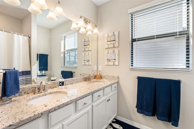 14309 Carolina Sky Pl, Lakewood Ranch, FL 34211 - bathroom with baseboards, an inviting chandelier, double vanity, and a sink