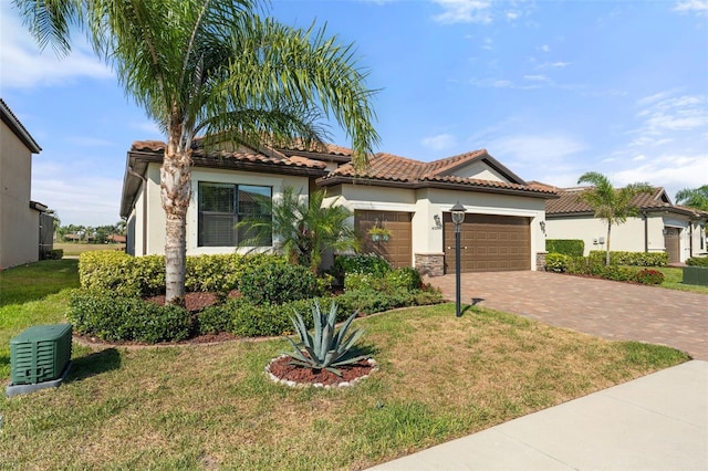 14309 Carolina Sky Pl, Lakewood Ranch, FL 34211 - mediterranean / spanish-style home with a front yard, stucco siding, decorative driveway, a tiled roof, and an attached garage