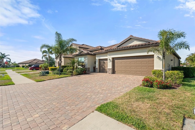 14309 Carolina Sky Pl, Lakewood Ranch, FL 34211 - view of front of house with stone siding, decorative driveway, a front yard, stucco siding, and a garage