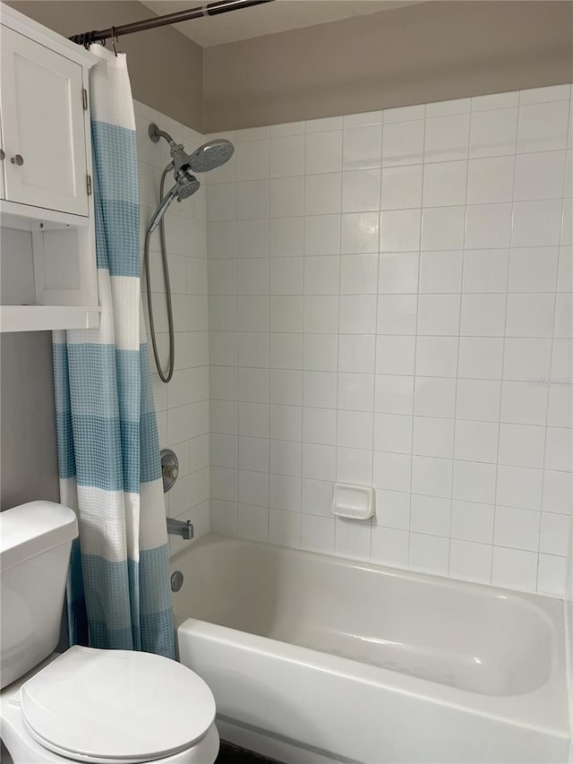 bathroom featuring shower / tub combo and toilet