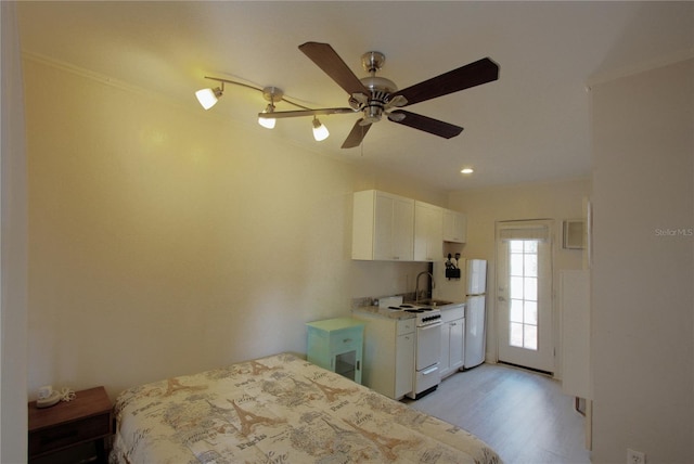 525 Rawls Ave, Sarasota, FL 34236 - bedroom with crown molding, a sink, freestanding refrigerator, a ceiling fan, and light wood-type flooring