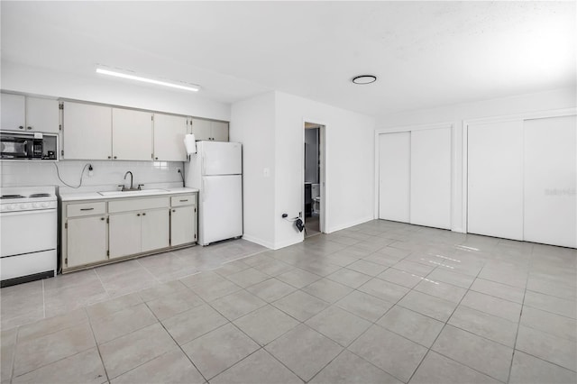 kitchen featuring light countertops, white appliances, a sink, and light tile patterned floors