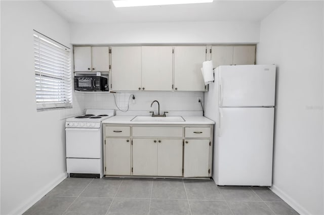 kitchen featuring light countertops, white appliances, a sink, and tasteful backsplash