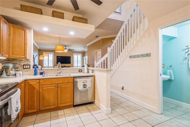 kitchen with ceiling fan, crown molding, a sink, a peninsula, and stainless steel appliances