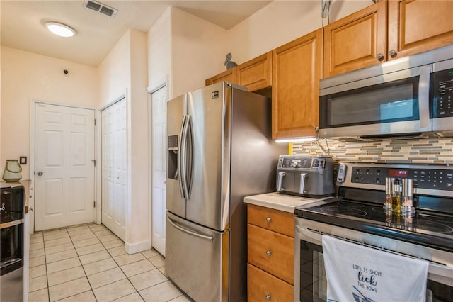 kitchen featuring visible vents, tasteful backsplash, light countertops, stainless steel appliances, and light tile patterned flooring