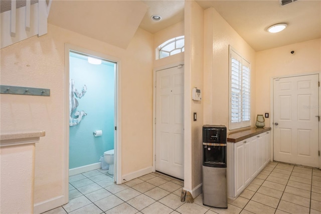entryway with baseboards, light tile patterned floors, and visible vents