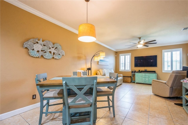 tiled dining area featuring crown molding, a ceiling fan, baseboards, and a healthy amount of sunlight