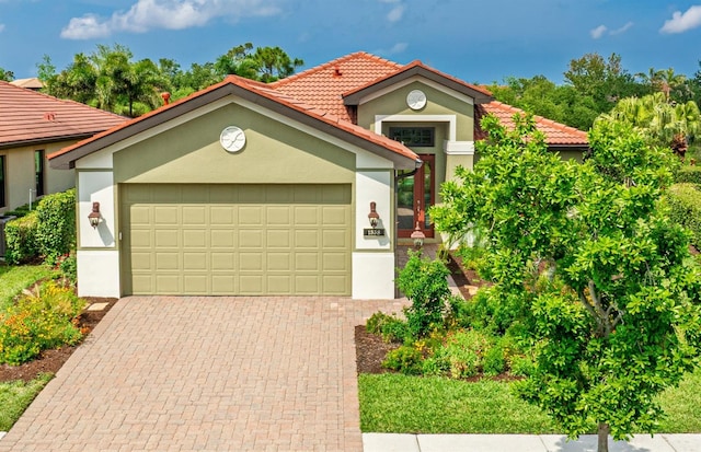 1358 Cielo Ct, North Venice, FL 34275 - mediterranean / spanish-style home featuring a tile roof, an attached garage, stucco siding, and driveway