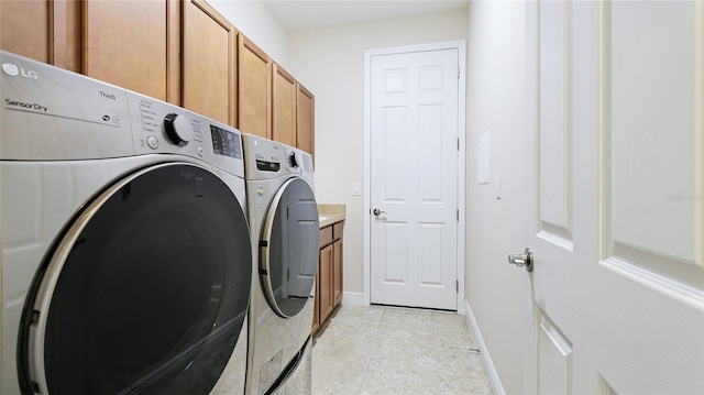 1358 Cielo Ct, North Venice, FL 34275 - laundry area featuring cabinet space, washer and clothes dryer, baseboards, and light tile patterned flooring