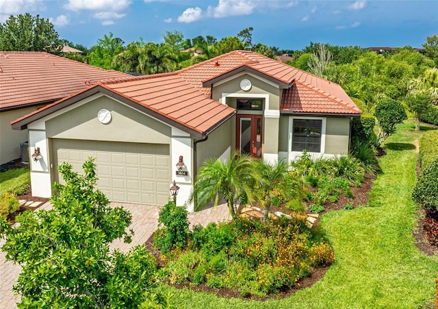 1358 Cielo Ct, North Venice, FL 34275 - mediterranean / spanish home with a tiled roof, stucco siding, a garage, and driveway