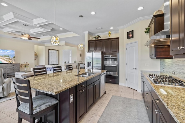 kitchen with decorative backsplash, a breakfast bar area, light tile patterned floors, appliances with stainless steel finishes, and a sink