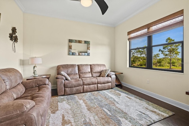 living area featuring baseboards, wood finished floors, a ceiling fan, and crown molding