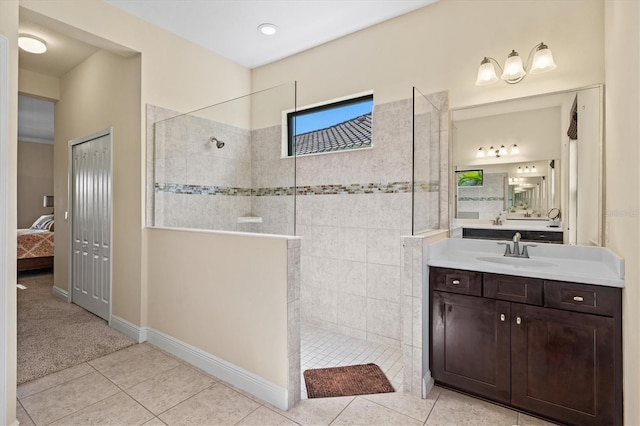 ensuite bathroom featuring tile patterned floors, a walk in shower, vanity, and connected bathroom