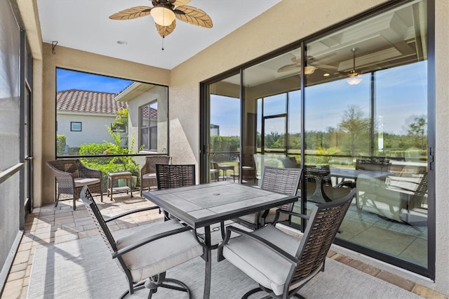 sunroom / solarium featuring outdoor dining area and a ceiling fan