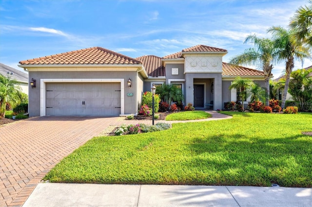 mediterranean / spanish-style house with stucco siding, decorative driveway, a front lawn, and an attached garage