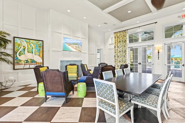 dining room featuring a decorative wall, french doors, recessed lighting, and a high ceiling