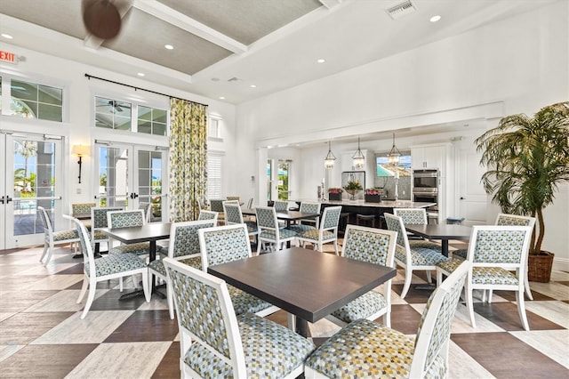 dining space featuring recessed lighting, beam ceiling, visible vents, a towering ceiling, and french doors