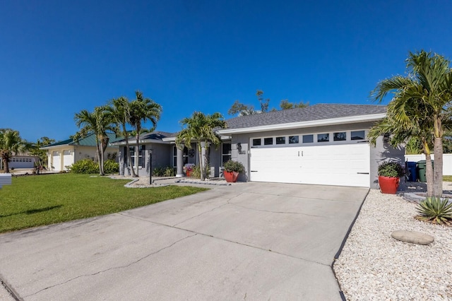 ranch-style home featuring an attached garage, driveway, stucco siding, and a front yard