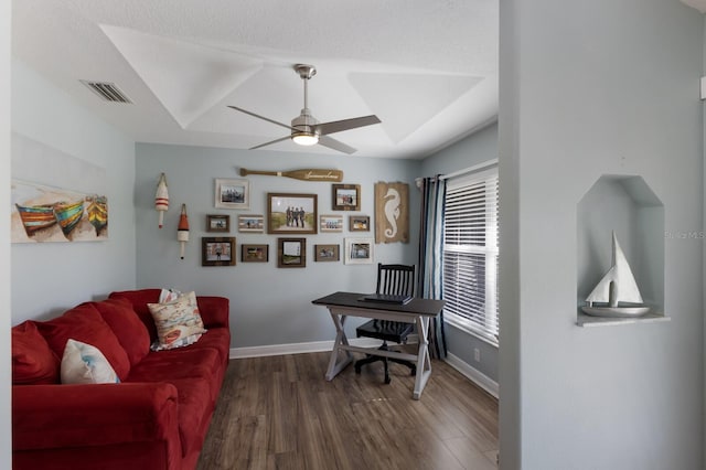 office featuring a ceiling fan, baseboards, visible vents, and dark wood finished floors