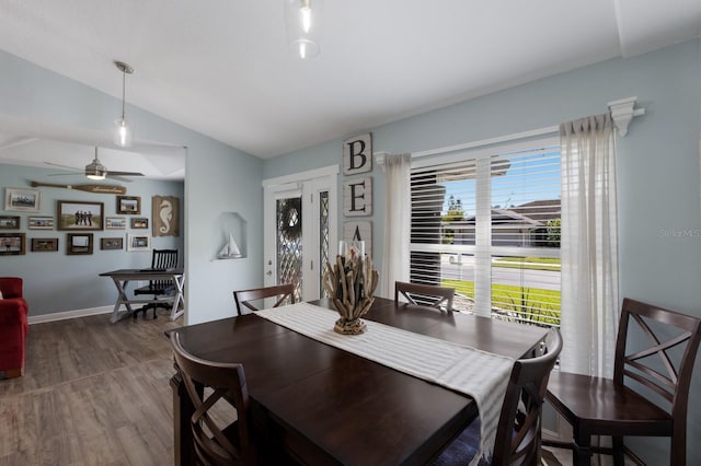 dining area with a ceiling fan, baseboards, wood finished floors, and lofted ceiling