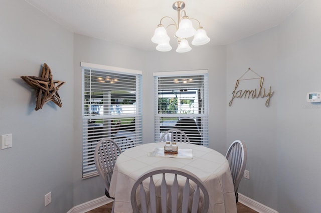 dining room featuring baseboards, a chandelier, and dark wood finished floors