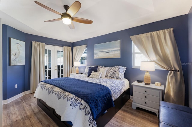 bedroom with wood finished floors, access to exterior, baseboards, french doors, and a ceiling fan