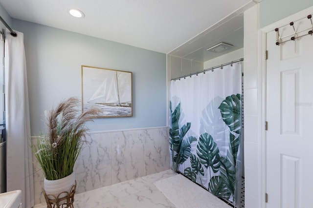full bath with a shower with curtain, recessed lighting, and marble finish floor