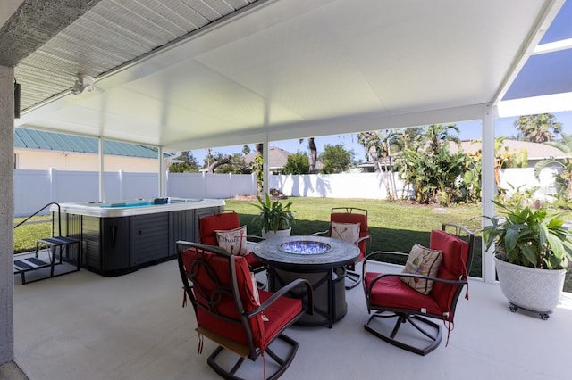 view of patio featuring a hot tub, a fire pit, and a fenced backyard