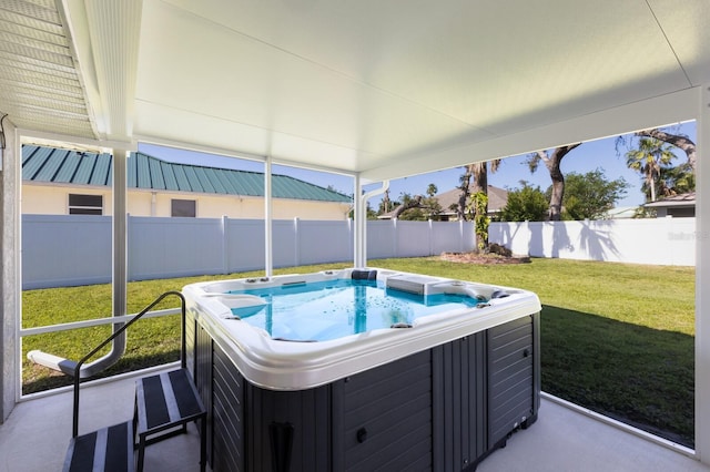 view of swimming pool with a fenced backyard, a hot tub, and a yard