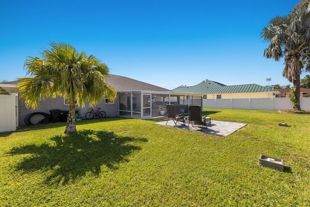 back of property featuring a lawn, a patio, fence, and a sunroom