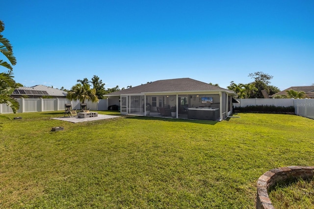 rear view of house with a sunroom, a patio area, a fenced backyard, a yard, and a fire pit