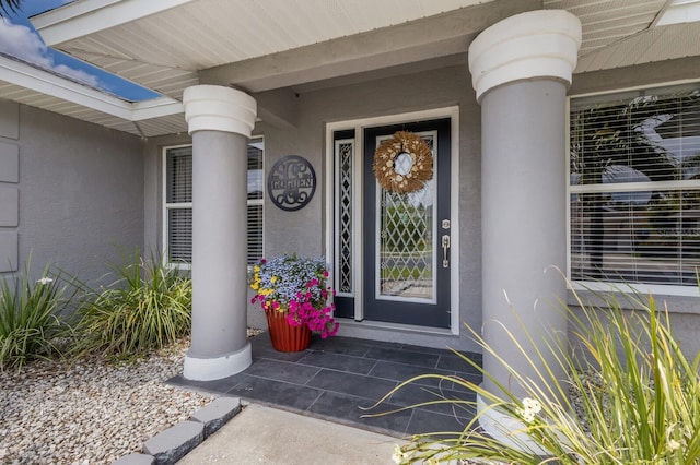 3889 Canopy Way, Sarasota, FL 34235 - doorway to property featuring stucco siding and a porch