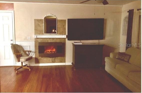 25 Philox Ln, Palm Coast, FL 32164 - living room featuring wood finished floors, a tiled fireplace, and ceiling fan