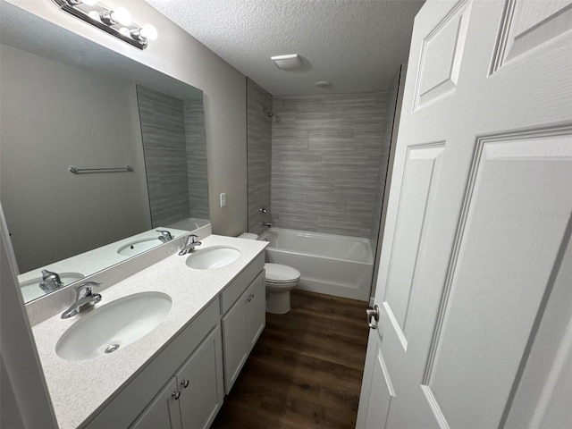 475 Tobias St SE, Palm Bay, FL 32909 - bathroom featuring double vanity, toilet, wood finished floors, shower / bathtub combination, and a textured ceiling