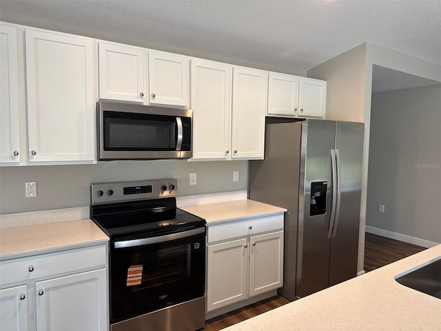 475 Tobias St SE, Palm Bay, FL 32909 - kitchen with appliances with stainless steel finishes, dark wood-type flooring, white cabinetry, and light countertops